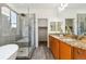 Bathroom with a spacious walk-in shower, dual vanity with granite countertop, and a luxurious soaking tub at 4935 S Zephyr St, Littleton, CO 80123