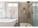 Close-up on bathroom featuring a tub and glass-enclosed shower showcasing modern design at 4935 S Zephyr St, Littleton, CO 80123