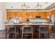 Kitchen island with granite counters, pendant lighting, wooden cabinets, and bar stool seating at 4935 S Zephyr St, Littleton, CO 80123