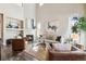 Open living room featuring a fireplace, tall windows, a large plant, and modern decor at 4935 S Zephyr St, Littleton, CO 80123