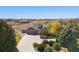 An elevated view of a home featuring mature landscaping, a three-car garage, and a circular driveway at 10044 E 146Th Pl, Brighton, CO 80602