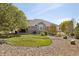 A landscaped backyard featuring a well-manicured lawn and large picture window at 10044 E 146Th Pl, Brighton, CO 80602