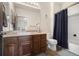 Traditional bathroom boasts wood-look tile, single vanity, and a shower-tub combo with dark blue curtain at 10044 E 146Th Pl, Brighton, CO 80602