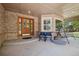 Inviting front porch with seating, wood door with decorative glass, and charming brick accents at 10044 E 146Th Pl, Brighton, CO 80602