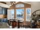 A bright breakfast nook with a table and kitchen featuring blue cabinets and a view at 10044 E 146Th Pl, Brighton, CO 80602