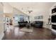 Bright living room with hardwood floors, vaulted ceiling, and two black leather couches at 10044 E 146Th Pl, Brighton, CO 80602