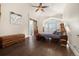 A primary bedroom with unique wood furniture, a ceiling fan, and ensuite bathroom with barn door at 10044 E 146Th Pl, Brighton, CO 80602