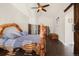 A well-lit primary bedroom with wood furniture, a ceiling fan, and an ensuite bathroom at 10044 E 146Th Pl, Brighton, CO 80602