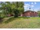 Well-maintained backyard with a brick house, grassy lawn, mature trees, and a small shed on a sunny day at 10452 Washington Way, Northglenn, CO 80233