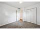 Neutral carpeted bedroom with white walls, closet and open doorway showcasing hardwood floor beyond at 10452 Washington Way, Northglenn, CO 80233