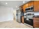 Kitchen with stainless steel appliances, tile flooring, and wooden cabinets at 10452 Washington Way, Northglenn, CO 80233