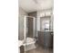 Compact bathroom with a glass-enclosed shower, gray tile, modern lighting, and sleek vanity at 1815 Grove St, Denver, CO 80204