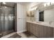 Modern bathroom with a walk-in shower, dual sinks, and a large mirror at 1815 Grove St, Denver, CO 80204