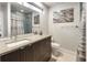 Modern bathroom featuring a sleek vanity, neutral gray tile shower with a glass enclosure and contemporary art at 1815 Grove St, Denver, CO 80204