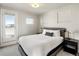 Bright bedroom with natural light, gray color palette, and a bed with minimalist bedside lamps at 1815 Grove St, Denver, CO 80204