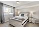 Bright bedroom features a large window, gray curtains, and a bed with wooden frame and matching nightstands at 1815 Grove St, Denver, CO 80204