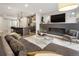 Open-concept living room features fireplace, TV, and view into the modern kitchen with an island at 1815 Grove St, Denver, CO 80204