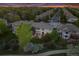 Aerial view of suburban neighborhood, showing home with manicured lawn, mature trees and twilight sky at 6095 S Oswego St, Greenwood Village, CO 80111