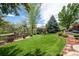 Well-maintained backyard featuring a manicured lawn, mature trees, and privacy fence, ideal for relaxation at 6095 S Oswego St, Greenwood Village, CO 80111