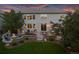 Beautiful backyard at dusk featuring a patio, fire pit, lush lawn, and mature trees, perfect for evening gatherings at 6095 S Oswego St, Greenwood Village, CO 80111