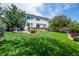 Expansive backyard featuring a lush lawn, mature trees, and patio area, providing ample space for outdoor activities at 6095 S Oswego St, Greenwood Village, CO 80111