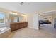 Elegant bathroom boasts dual sinks, large mirror, and access to the bedroom at 6095 S Oswego St, Greenwood Village, CO 80111