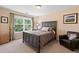 Cozy bedroom with large window, comfortable bed, and accent chair at 6095 S Oswego St, Greenwood Village, CO 80111