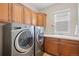 Modern laundry room with stainless steel washer and dryer, cabinets, and a sink at 6095 S Oswego St, Greenwood Village, CO 80111