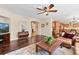 Open-concept living room with hardwood floors, a large wooden coffee table, and an adjacent dining area at 6095 S Oswego St, Greenwood Village, CO 80111