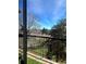 Relaxing balcony view with metal railing, artificial turf, and decorative sun ornament against a backdrop of lush greenery and blue sky at 4899 S Dudley St # K18, Littleton, CO 80123