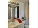 Bathroom vanity with sink, mirror, and lighting plus an open view to the toilet and bathtub/shower at 4899 S Dudley St # K18, Littleton, CO 80123