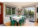 Dining room with green chairs, wood floors, and large windows providing stunning views of the surrounding landscape at 159 Lake Rd, Idaho Springs, CO 80452