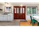 Bright entryway featuring a statement wooden door, adjacent to a modern kitchen area and dining space at 159 Lake Rd, Idaho Springs, CO 80452