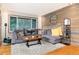 Comfortable living room showcasing a stylish sectional sofa, rustic wood accent wall, and picturesque window views at 159 Lake Rd, Idaho Springs, CO 80452