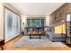 Charming living room with a plush gray sectional sofa, wood accent wall, and natural light from large windows at 159 Lake Rd, Idaho Springs, CO 80452