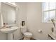 Well-lit half bathroom featuring a pedestal sink and a window at 27893 E 6Th Pl, Aurora, CO 80018