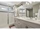 Elegant bathroom with a glass-enclosed shower, double sink vanity, and stylish lighting fixtures at 27893 E 6Th Pl, Aurora, CO 80018