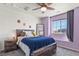 Charming bedroom featuring natural wood bed frame, fun accent wall, and ample natural light at 27893 E 6Th Pl, Aurora, CO 80018