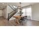 Stylish dining area featuring hardwood floors, a modern light fixture, and a staircase at 27893 E 6Th Pl, Aurora, CO 80018