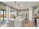 Bright kitchen showcasing a large island, white cabinetry, stainless steel appliances, and a view to the patio at 27893 E 6Th Pl, Aurora, CO 80018