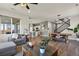 Open-concept living area with seamless flow to dining and kitchen, featuring stylish decor and hardwood floors at 27893 E 6Th Pl, Aurora, CO 80018