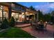 Spacious backyard patio with an outdoor kitchen, dining area, and a cozy fireplace at 10258 Pennington Ln, Highlands Ranch, CO 80126