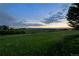 Picturesque backyard view of a grassy field and mountains at sunset at 10258 Pennington Ln, Highlands Ranch, CO 80126