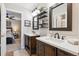 Bathroom with dual vanities, dark wood cabinetry, and a peek into the bedroom at 10258 Pennington Ln, Highlands Ranch, CO 80126