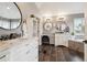 Bright bathroom featuring double sinks, round mirrors, vanity and a soaking tub at 10258 Pennington Ln, Highlands Ranch, CO 80126