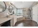 Bright bathroom featuring double sinks, large mirror, vanity and a glass shower at 10258 Pennington Ln, Highlands Ranch, CO 80126