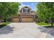 Well-maintained two-story home featuring a brick facade, three-car garage, and manicured landscaping at 10258 Pennington Ln, Highlands Ranch, CO 80126