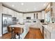 Bright kitchen features white cabinets, stainless appliances, and center island with seating at 10258 Pennington Ln, Highlands Ranch, CO 80126