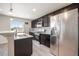 Well-equipped kitchen with stainless steel appliances, dark cabinets, and a bright window over the sink at 1732 Aspen Meadows Cir, Federal Heights, CO 80260