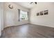 Bright living room featuring soaring ceilings, wood-look floors, and a large window with charming curtains at 1732 Aspen Meadows Cir, Federal Heights, CO 80260